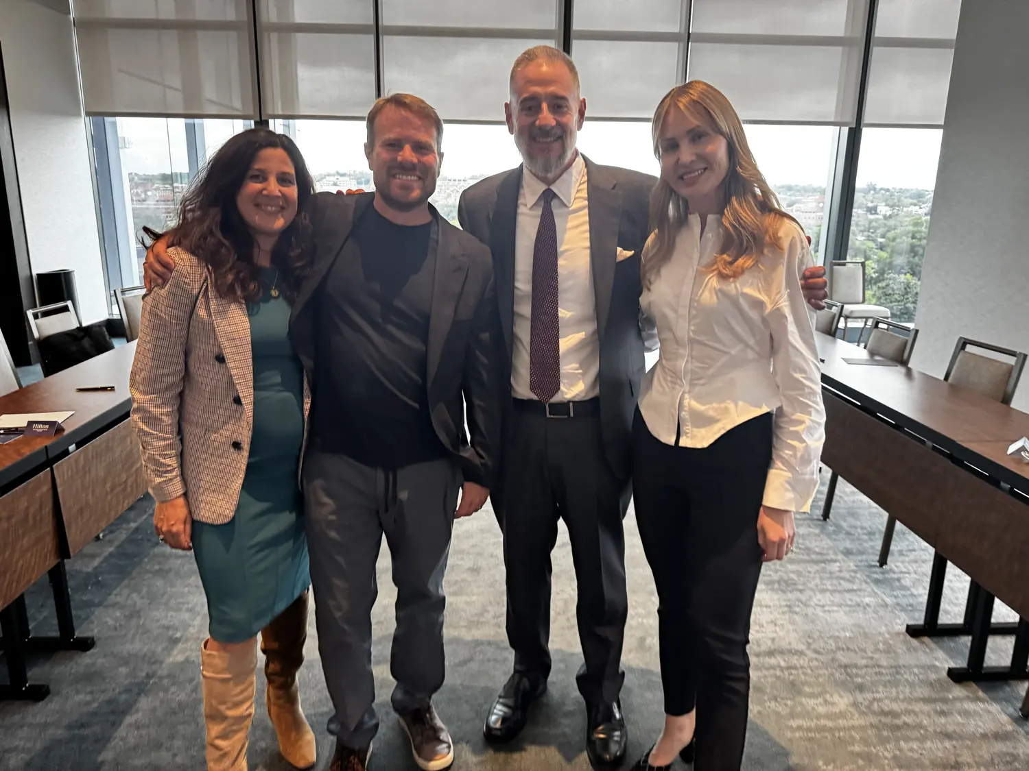Brent Nickles with his wife and co-founder Jen Nickles and Joey and Katya Battista in a conference room with city views